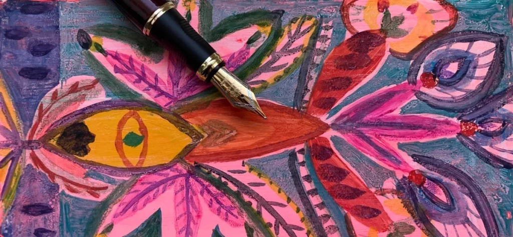 A colorful illustration resembling a flower, with an old-fashioned fountain pen atop it. It symbolises the fusion of written words and imagery.